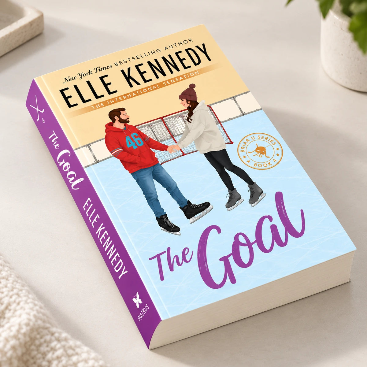 The Goal by Elle Kennedy hardcover book displayed on a tabletop in a cozy reading setup