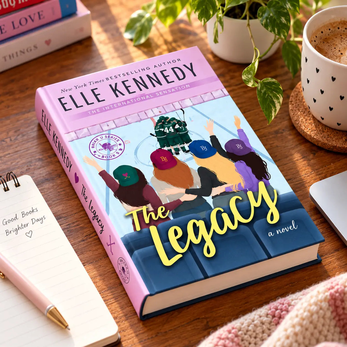 The Legacy by Elle Kennedy hardcover displayed on a wooden table in a cozy lifestyle setting