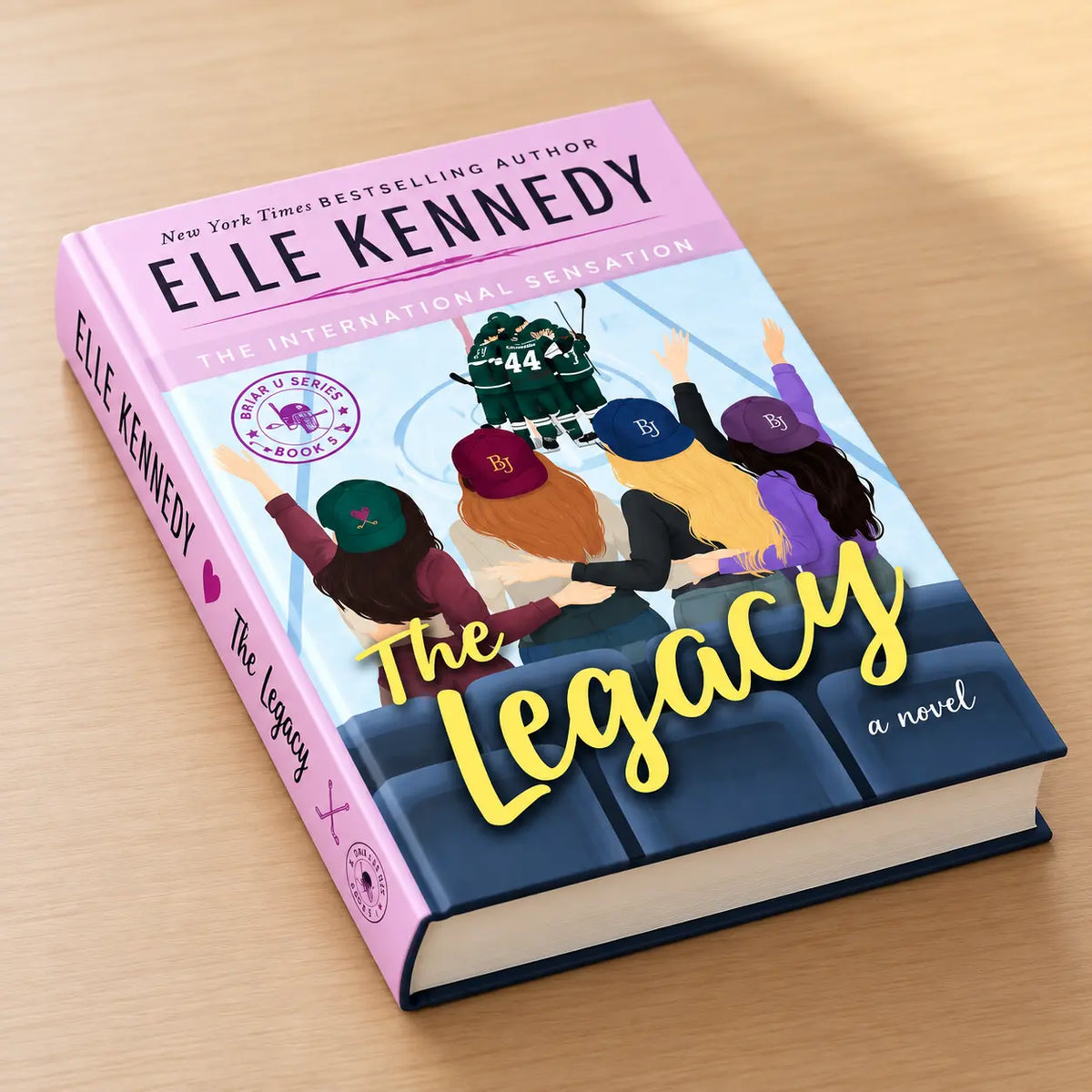 The Legacy by Elle Kennedy hardcover showing the pink spine, book cover, and cream page edges
