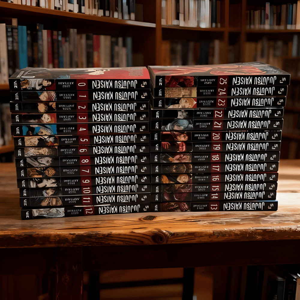 Two stacks of Jujutsu Kaisen manga volumes are arranged on a wooden table in front of a blurry bookshelf.